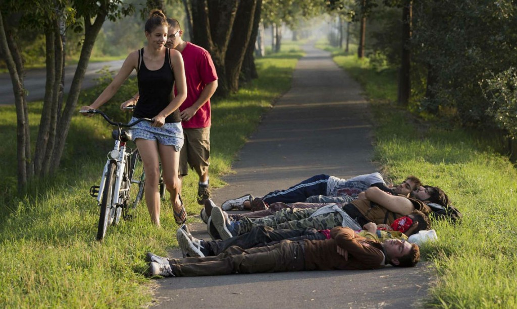 Europe-Refugee-Crisis-Local-cyclists-pass-a-group-of-refugees-sleeping-on-a-bicycle-path